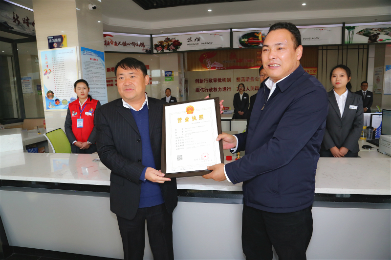 2、杨中华（右）为企业颁发经开区行政审批局办理的第一份营业执照。.jpg